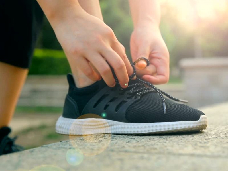 osoba vezuje pertle na patikama