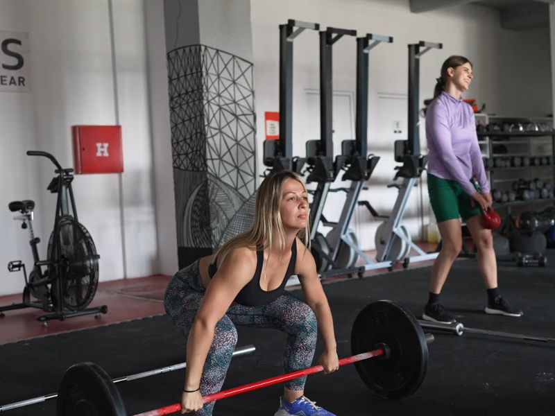 devojke treniraju u teretani obučene u sportsku odeću