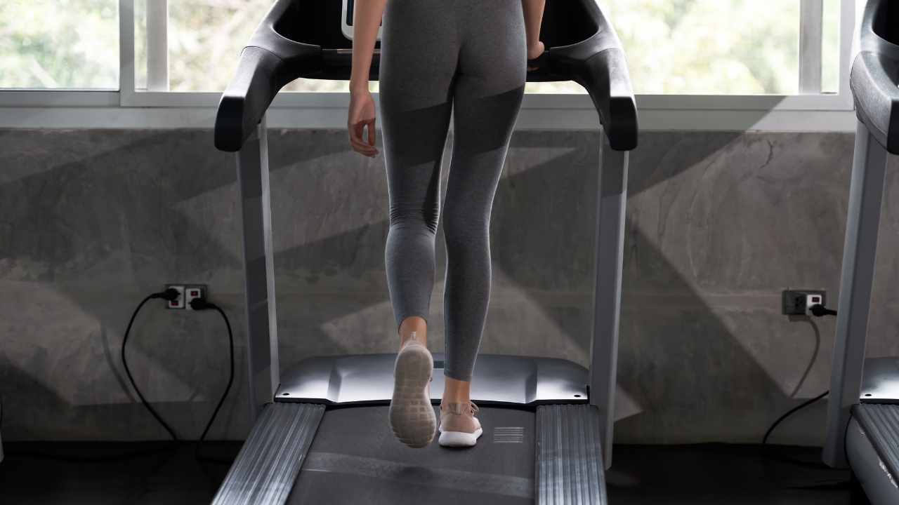 Osoba hoda na traci za trčanje u teretani